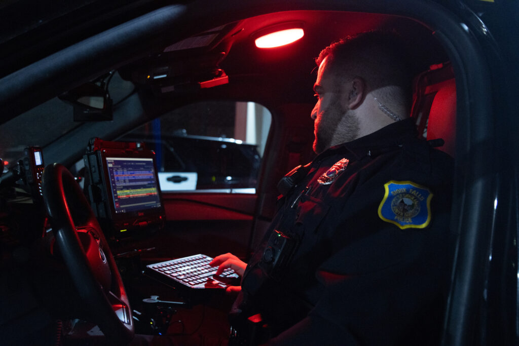 police officer working on computer in car